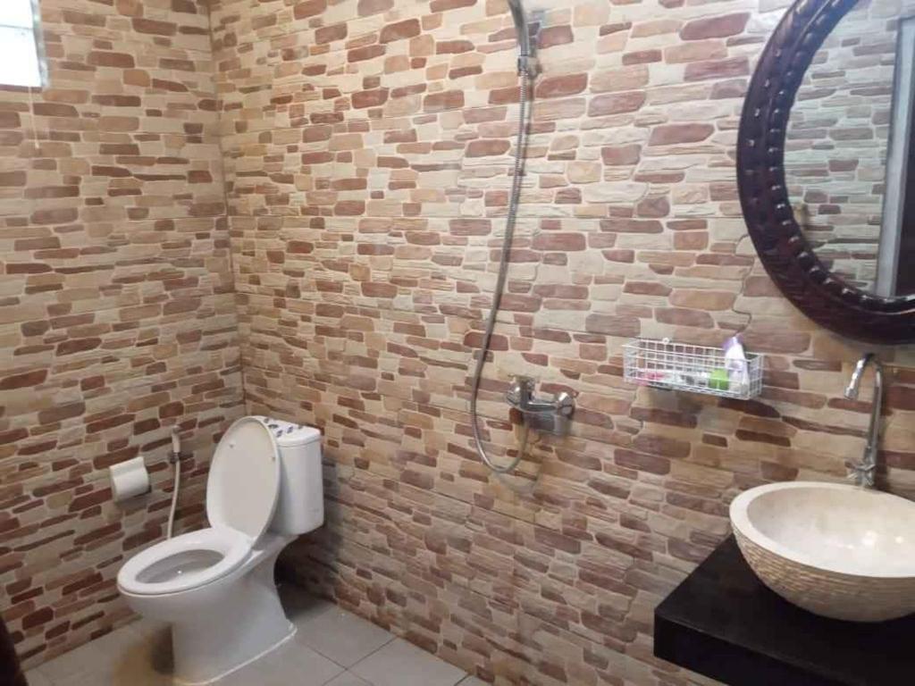 ein Badezimmer mit Toilette und Waschbecken in der Unterkunft Villa Almond Mayo in Gili Trawangan