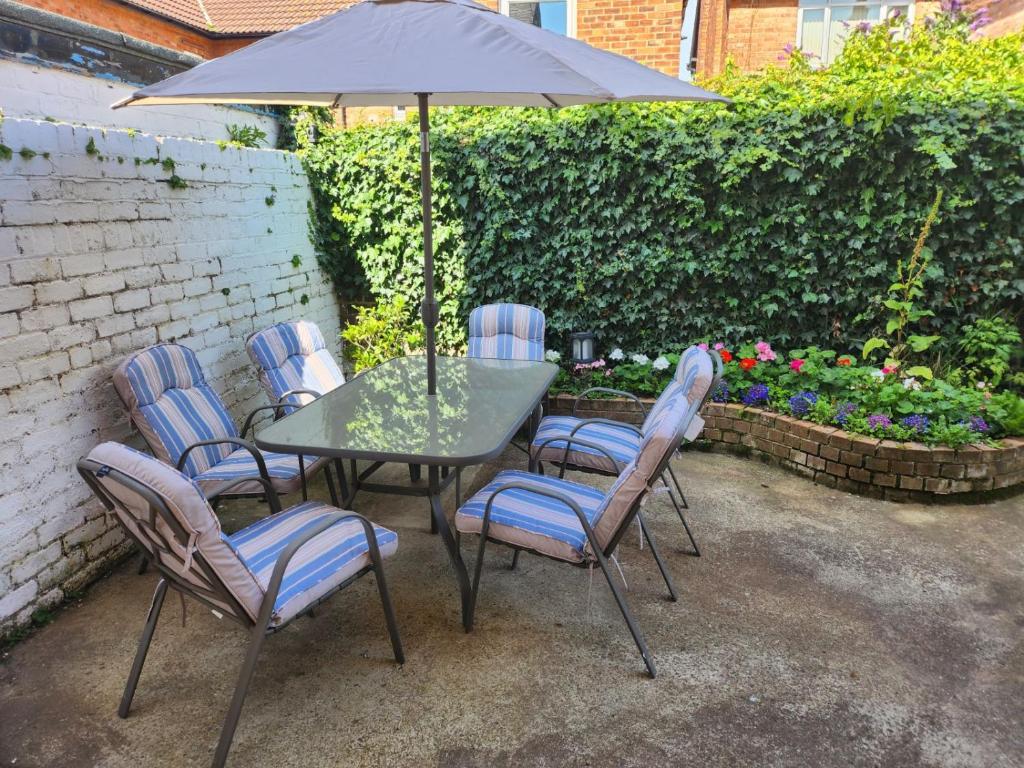 a table and chairs with an umbrella on a patio at Lovely 2-Bed Apartment in Bridlington in Bridlington