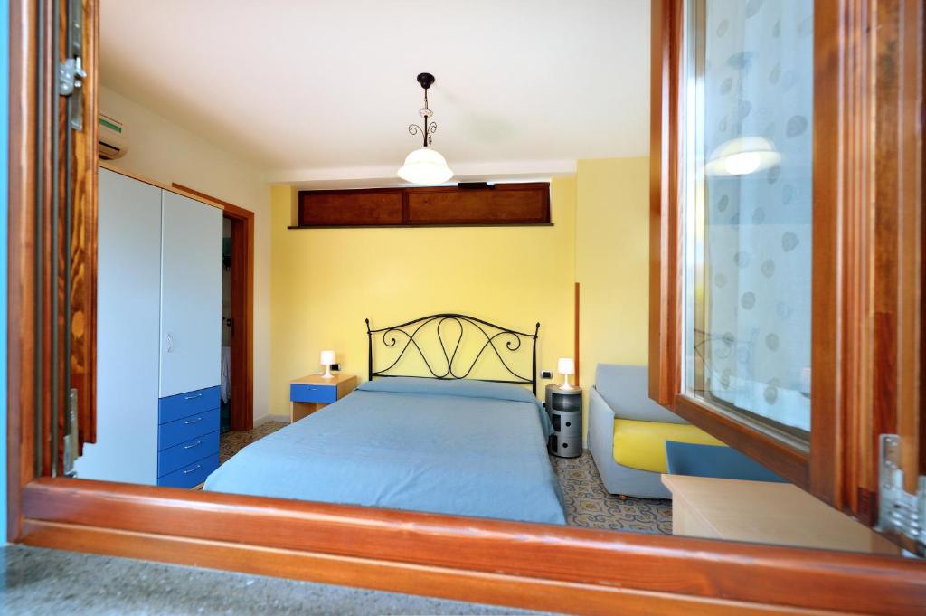 a bedroom with a blue bed and a couch at La Capannina in Procida