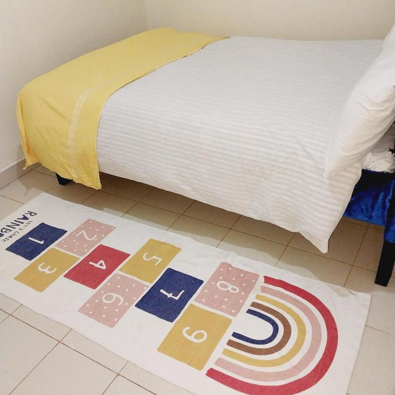 um tapete no chão ao lado de uma cama em Iona suits em Nairobi