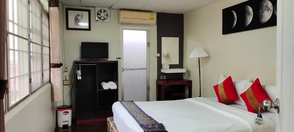 - une chambre avec un lit et une télévision dans l'établissement Born Guest House, à Chiang Mai