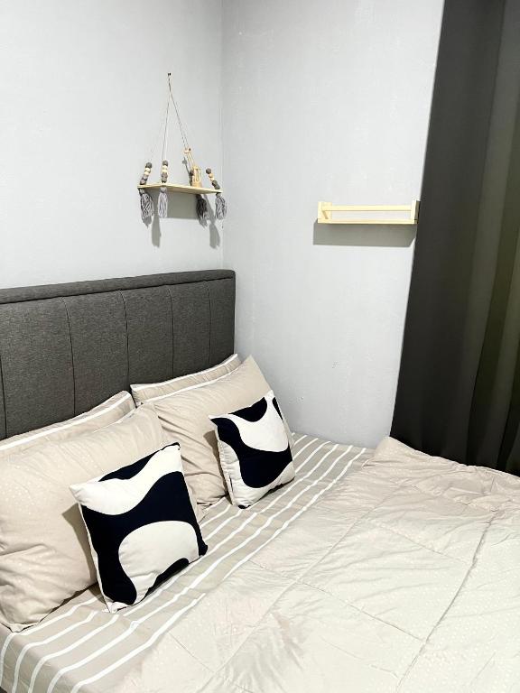 a bed with two black and white pillows on it at Modern Style Village House in Kuching