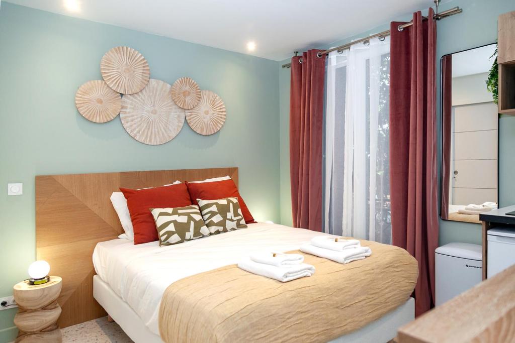 パリにあるNets Inn Apartments - Buttes Chaumont Dのベッドとタオル2枚のある寝室