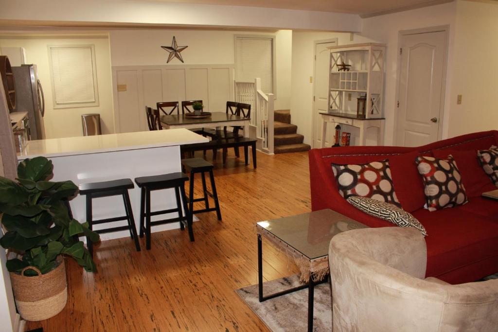 a living room with a red couch and a kitchen at Perfect home for families, groups, and gatherings in Atlanta