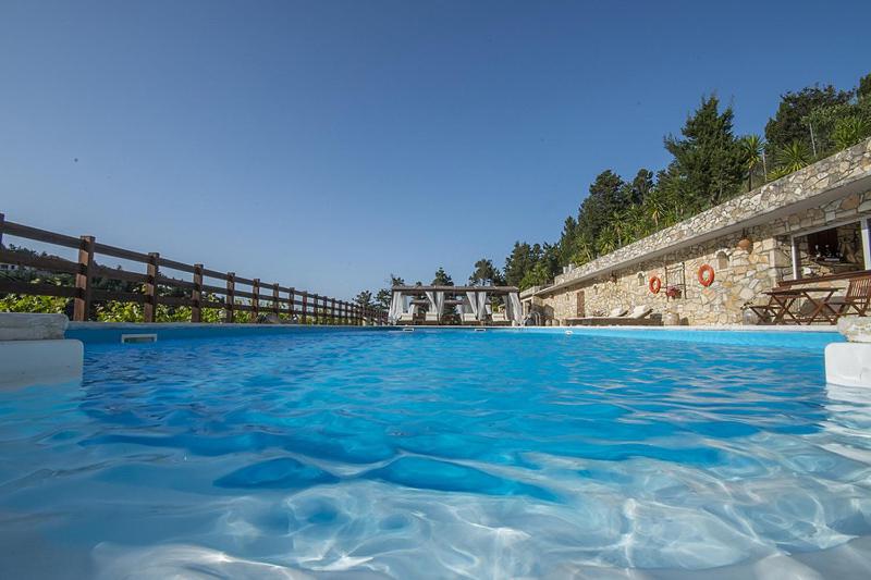 una grande piscina con acqua blu di Paxos Santa Marina Villas a Gaios