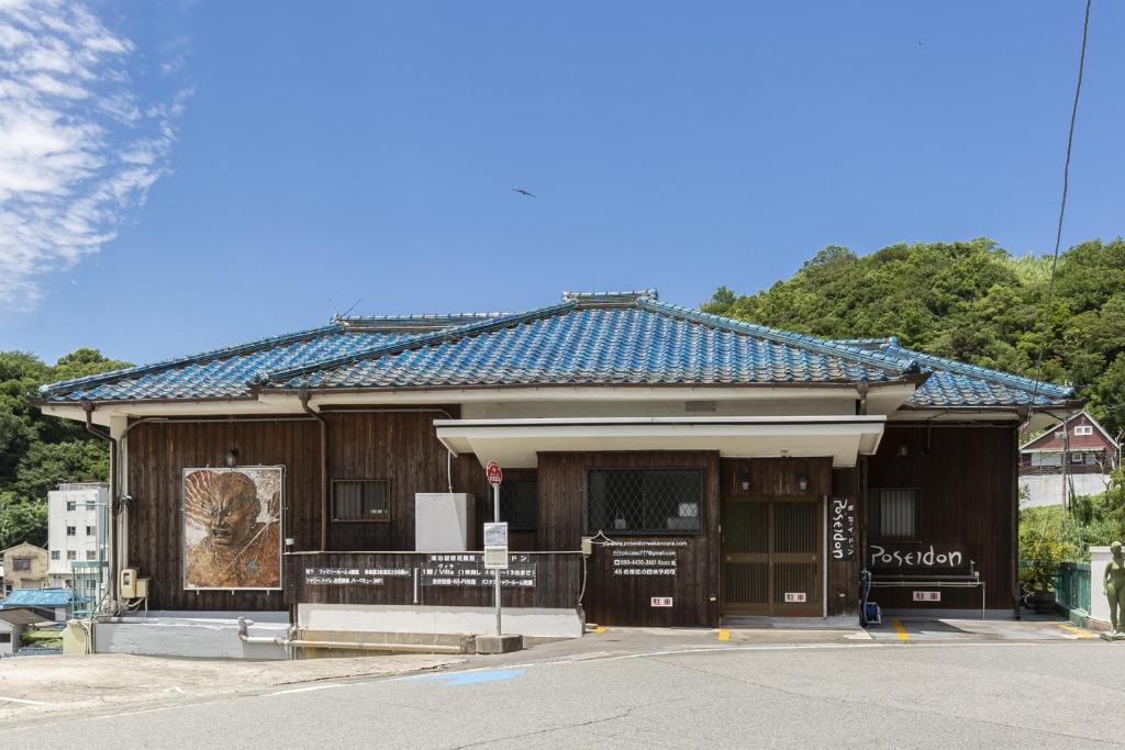 un pequeño edificio con un cartel delante en 和歌浦Poseidon家族団体専用個室, en Wakayama