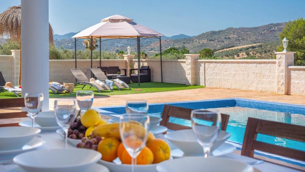 a table with a plate of fruit and wine glasses at Casa Rio Grande 2 Tolox by Ruralidays in Tolox