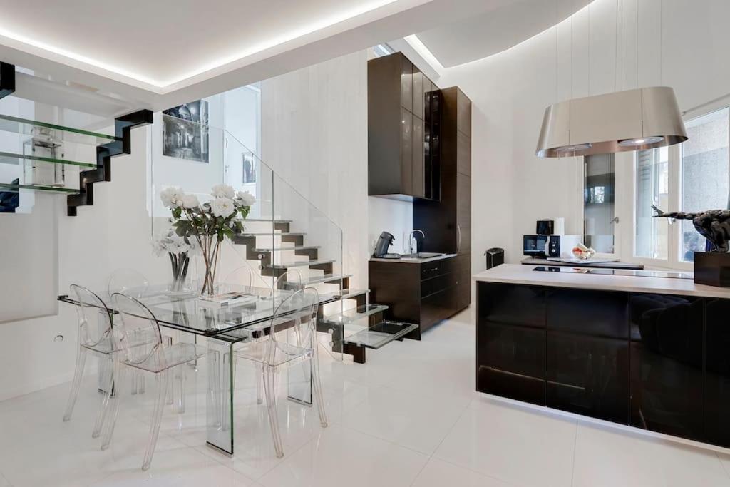 ein Esszimmer mit einem Glastisch und einer Treppe in der Unterkunft Luxury modern two bedroom duplex by Roland Garros in Paris