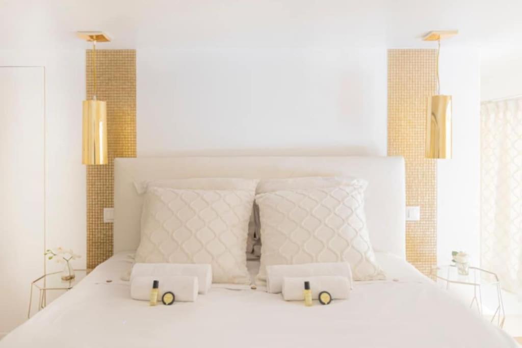a bedroom with a white bed with two white pillows at Luxury modern two bedroom duplex by Roland Garros in Paris