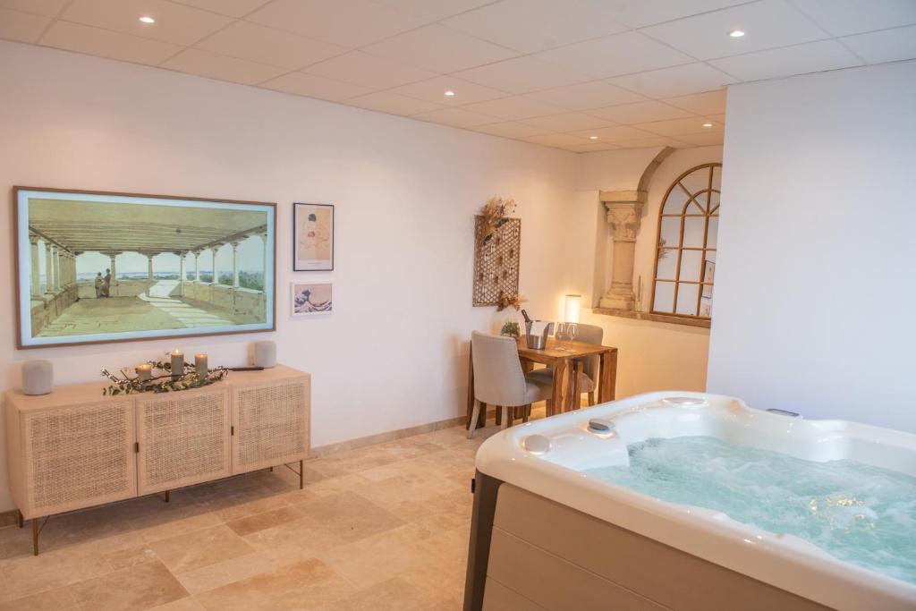 a large bathroom with a tub in a room at Couvent des Cordelières supplément SPA in Vezins