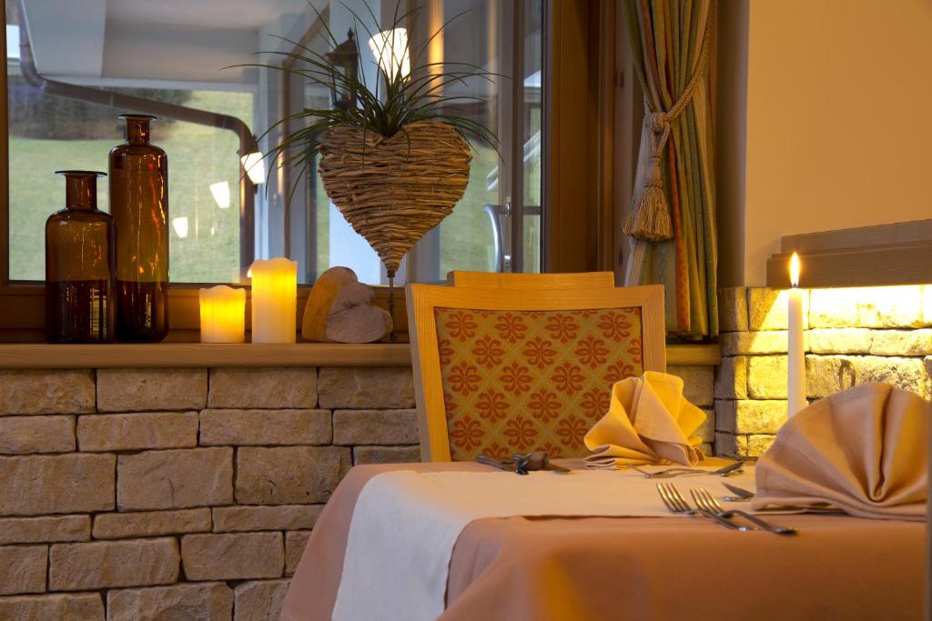 a dining room with a table with a chair and a plant at Hotel Bergland in Pertisau