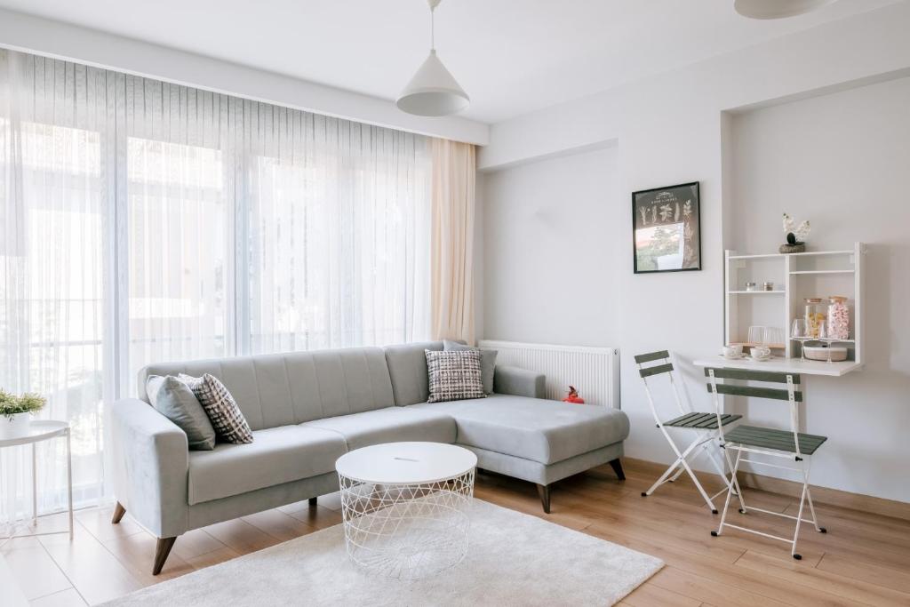 ein Wohnzimmer mit einem Sofa und einem Tisch in der Unterkunft Chic Flat w Balcony 5 min to Moda Coast in Kadikoy in Istanbul