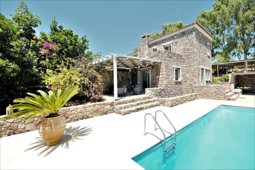 a villa with a swimming pool and a house at Miss Valentina-Modern Stone Villa in Aegina in Aegina Town
