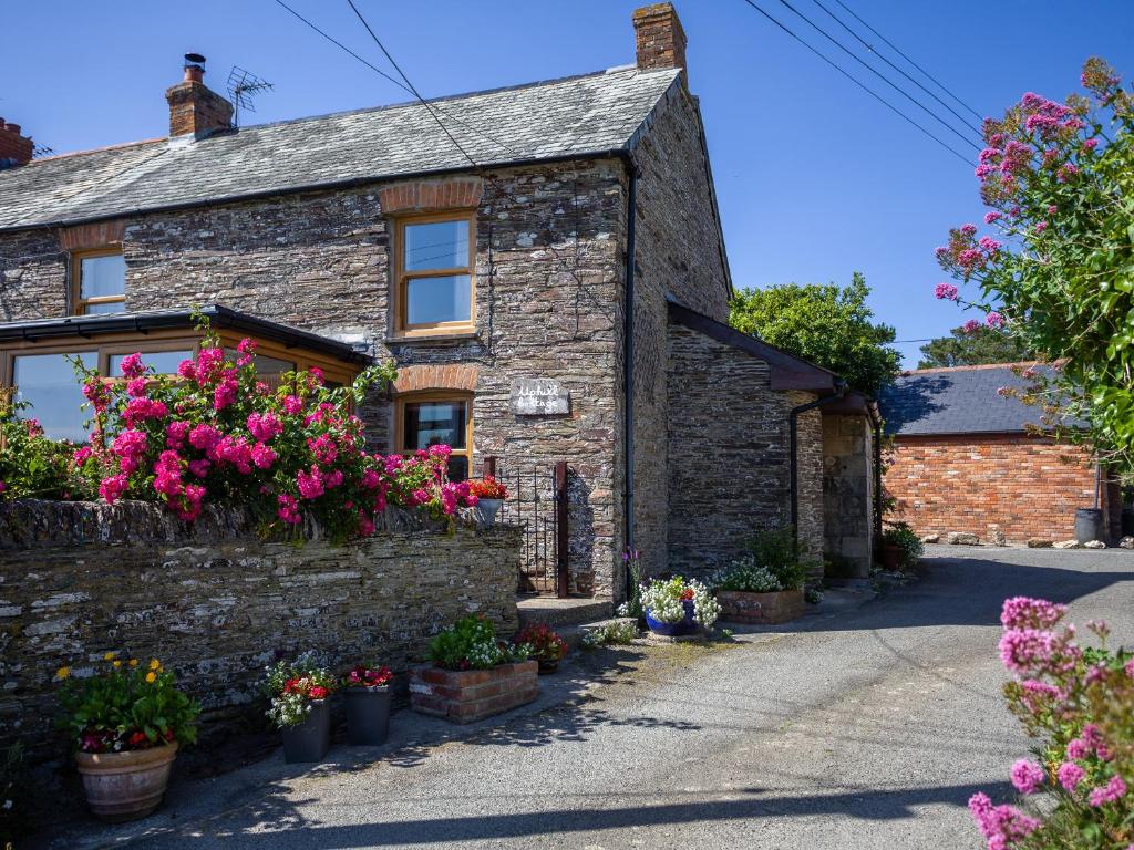 a stone house with flowers on the side of it at Uphill Cottage in Saint Ervan