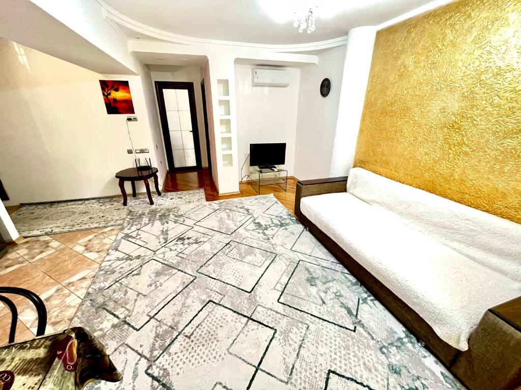 ein Wohnzimmer mit einer Couch und einem Teppich in der Unterkunft Уютная евро двушка в центре Алматы #57 in Almaty
