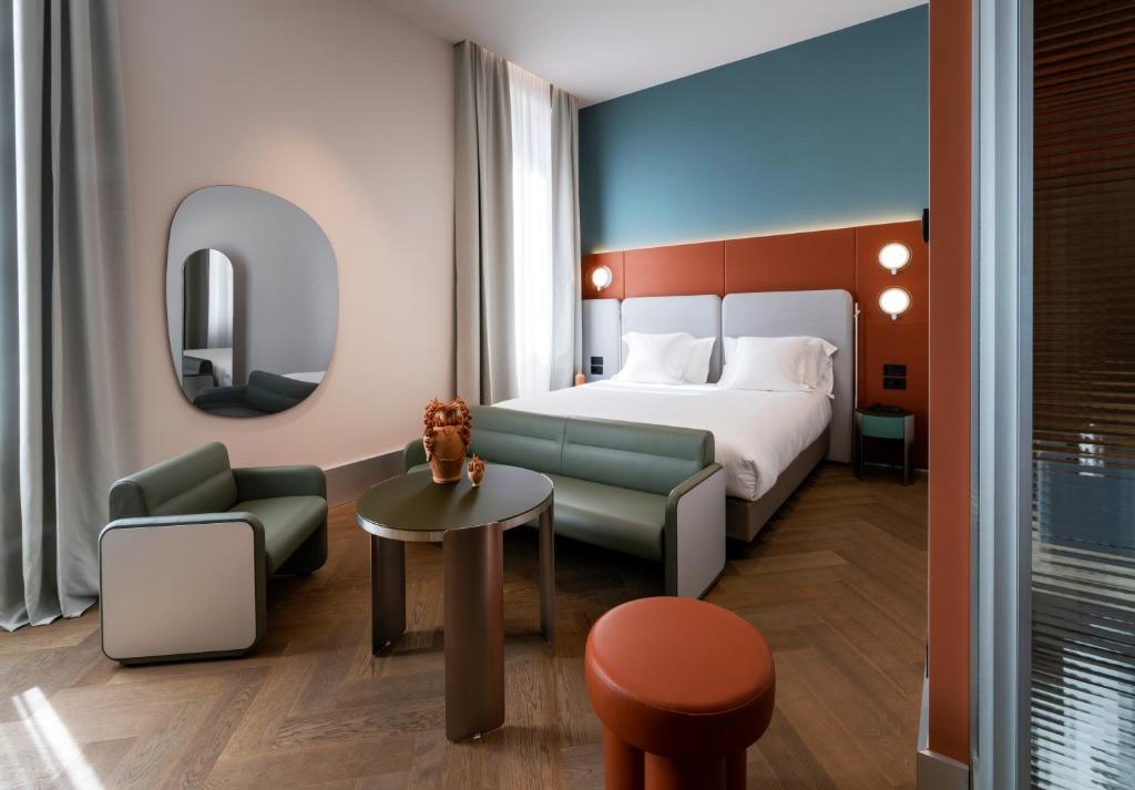 a hotel room with a bed and a table at Palazzo Tirso MGallery Cagliari in Cagliari