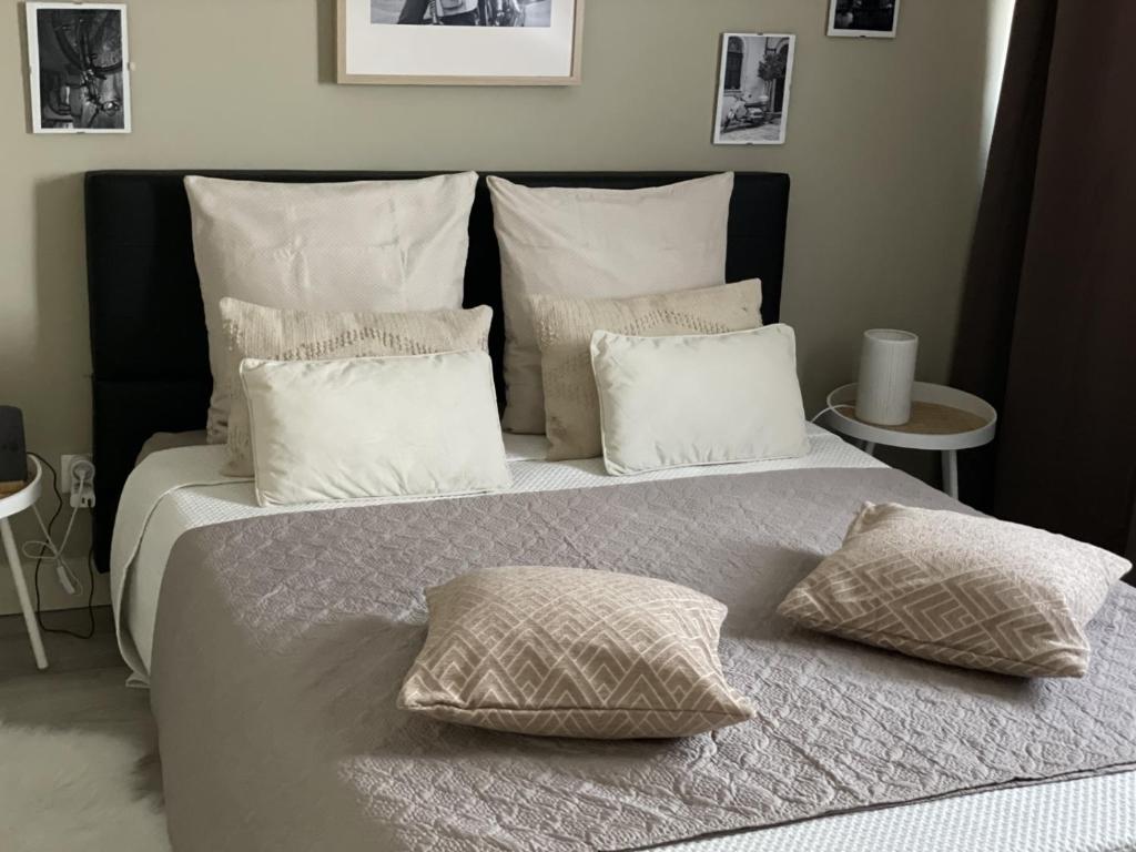 uma cama grande com almofadas brancas em cima em Chez Flo em Avignon