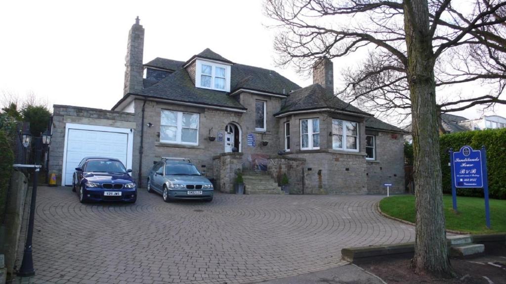 dos autos estacionados frente a una casa en Sandilands House, en Edimburgo