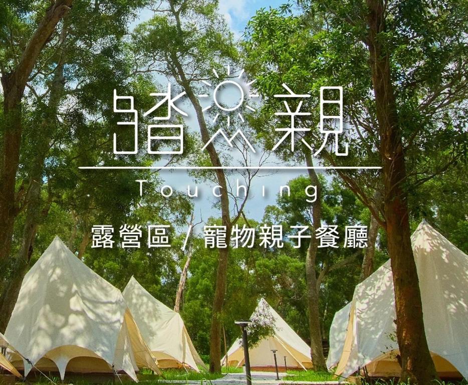 a sign with a group of tents in a park at Touching Camping in Hou-lung-tzu