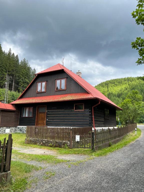 Valašská BystřiceにあるLudvíkova Chalupaの赤い屋根の大木造家屋