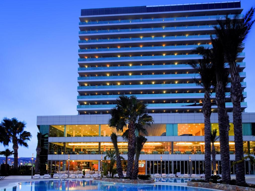 a large building with palm trees in front of it at AR Diamante Beach & SPA Hotel 4 SUP in Calpe