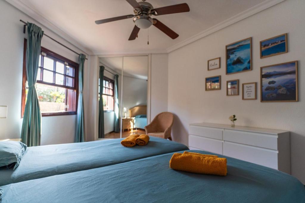a bedroom with a blue bed with a fan at Apartment Marzipans'Oasis in San Miguel de Abona