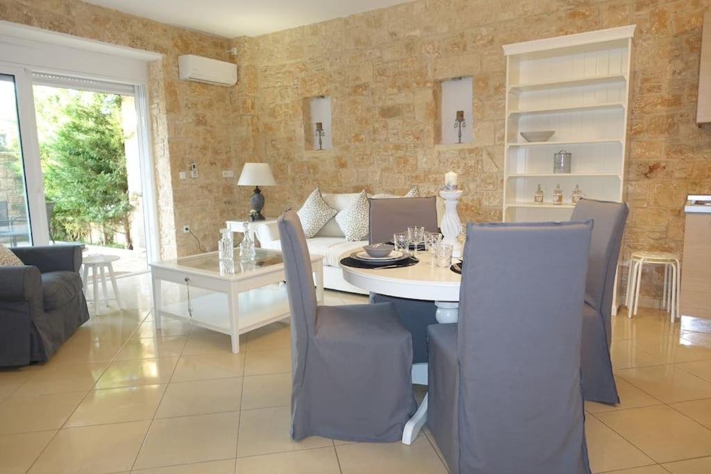 Miss Nefeli - Marvelous Stone Apartment in Perdika-Aegina في ايجينا تاون: غرفة طعام مع طاولة بيضاء وكراسي