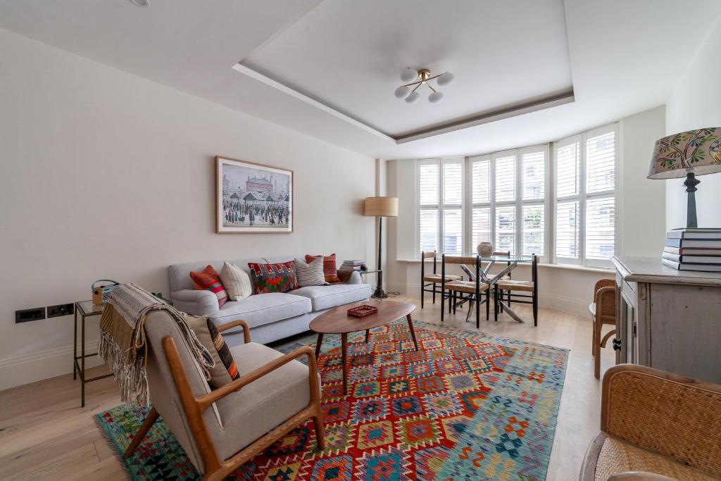 a living room with a couch and a table at Primary Located Splendid 2BR flat near Hyde Park in London