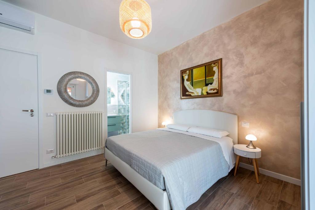 1 dormitorio con cama y espejo en la pared en MARCANTONIO ROOM Ampia camera con bagno privato e self check in, en Perugia