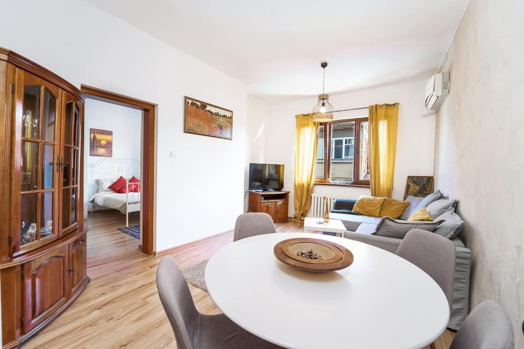 uma sala de estar com uma mesa branca e cadeiras em Central Apartment 2BD Next to Vitosha Bul. em Sófia