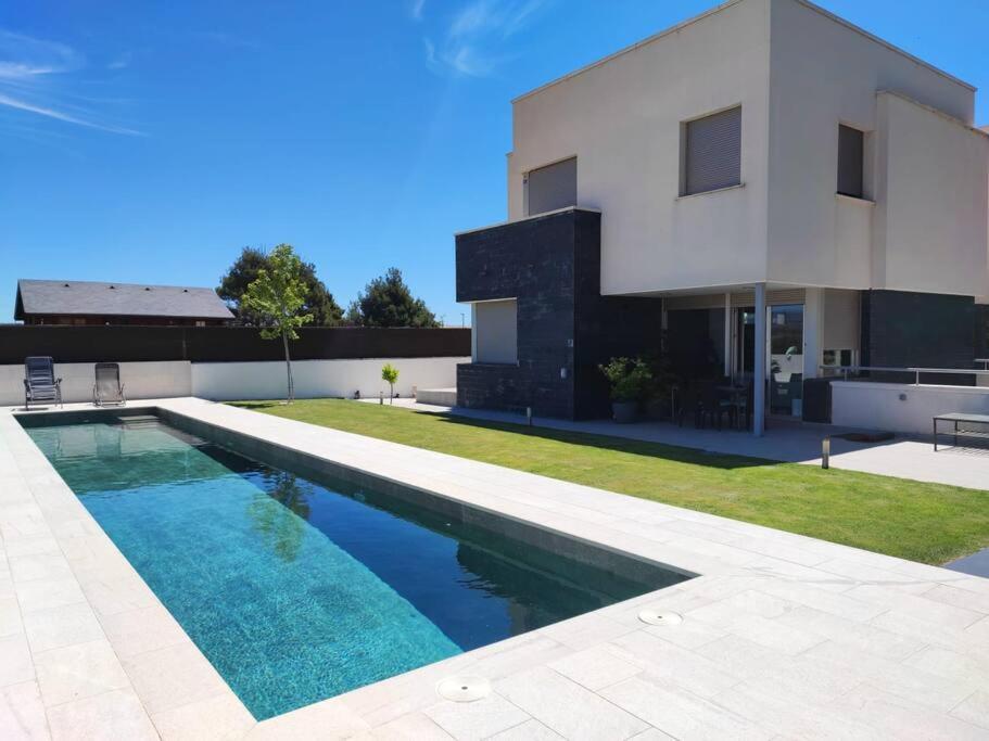ein Swimmingpool vor einem Haus in der Unterkunft Villa Oasis en Madrid con 3Hab, 4baños y elegante piscina in Villanueva del Pardillo