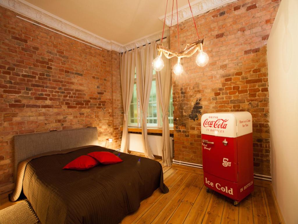 ベルリンにあるSmart Appart Atelier Berlinのベッドとレンガの壁が備わるコカコーラルーム