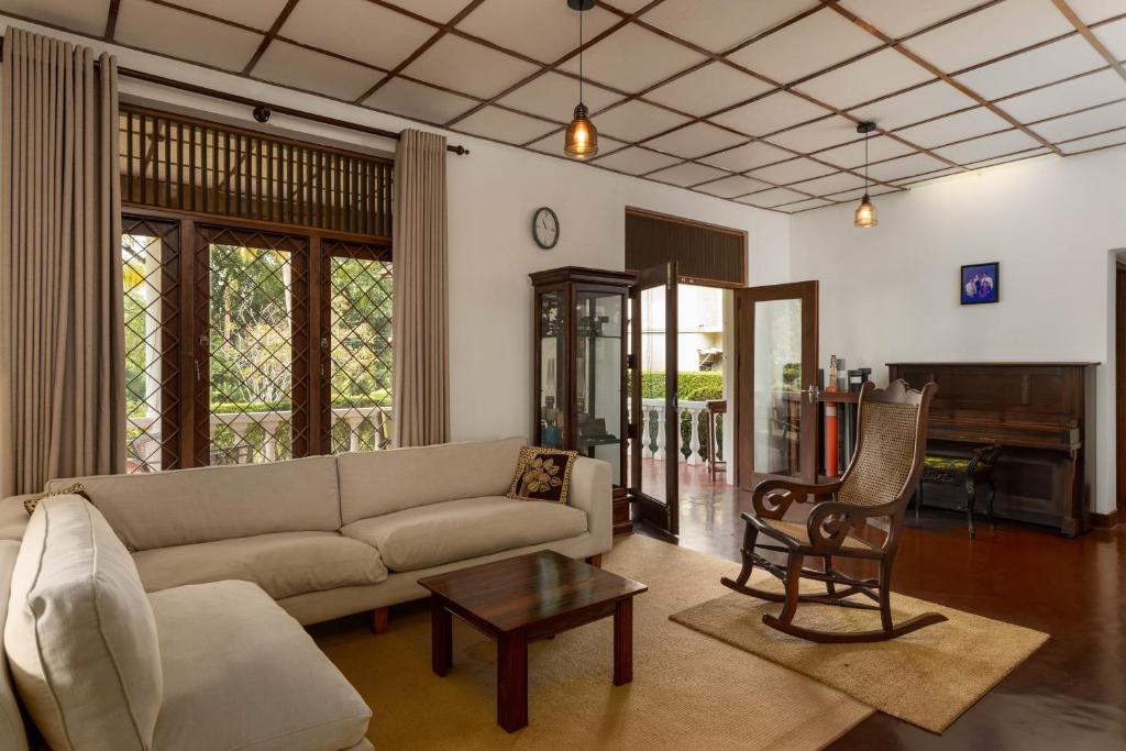 uma sala de estar com um sofá e uma mesa em Surveyor's Residence Bungalow em Kandy