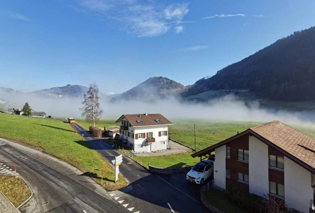 vistas a un pueblo con niebla en las montañas en Wohnung auf dem Bürgenstock, en Kehrsiten