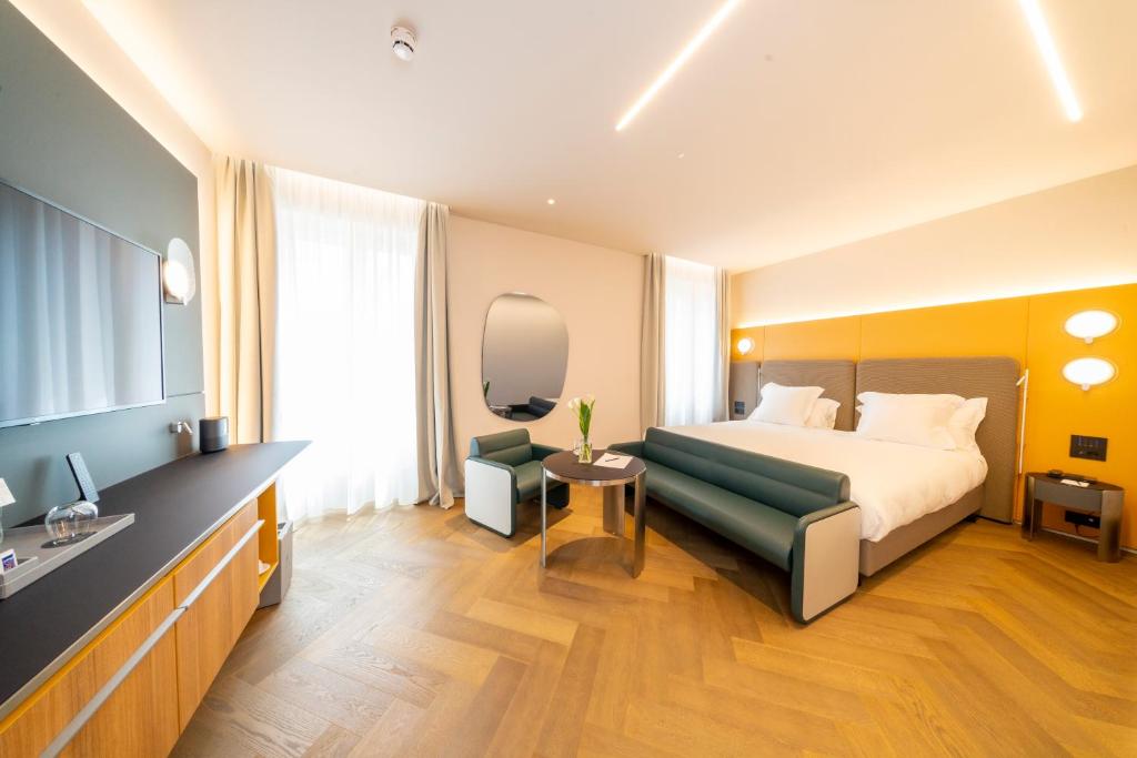 a hotel room with a bed and a chair at Palazzo Tirso MGallery Cagliari in Cagliari