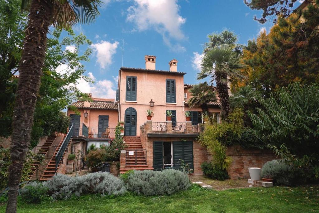 une vieille maison avec des palmiers devant elle dans l'établissement Ai Giardini di San Vitale, à Ravenne