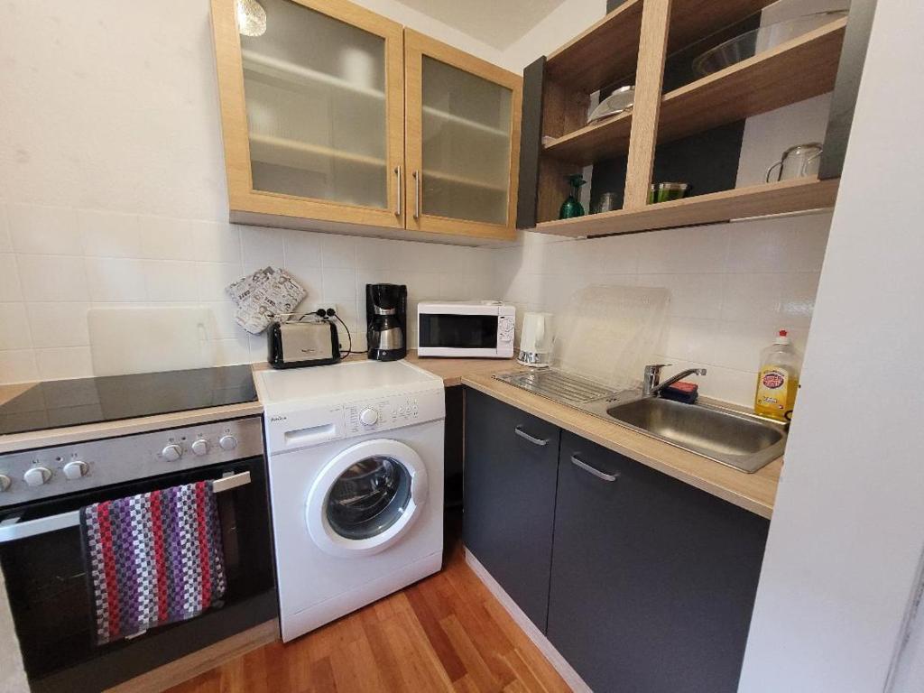 a kitchen with a washing machine and a sink at Marcel's Appartement in Bielefeld