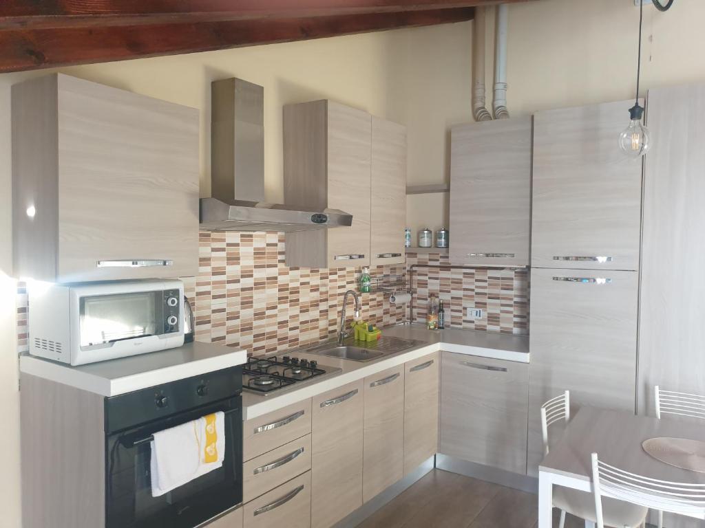 una cucina con forno a microonde e piano cottura forno superiore di Monolocale Seveso - Affitti brevi - Residence a Seveso