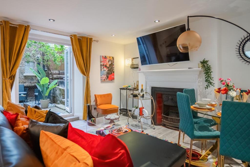 a living room with a couch and a fireplace at Livestay-Funky Trendy Modern 3 Bed 3 Bath House In Dalston in London