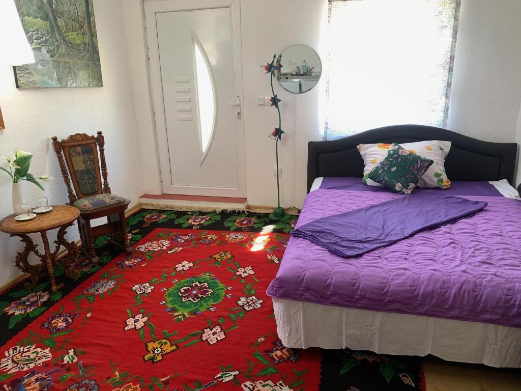 1 dormitorio con cama morada y alfombra roja en U Villi BB Gornji Zalik bb, en Mostar