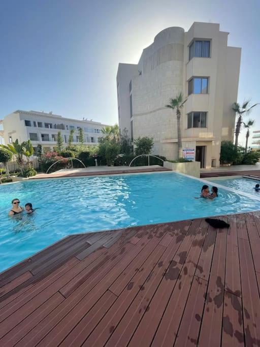 a group of people swimming in a large swimming pool at Superbe appartement à mohammadia in Mohammedia