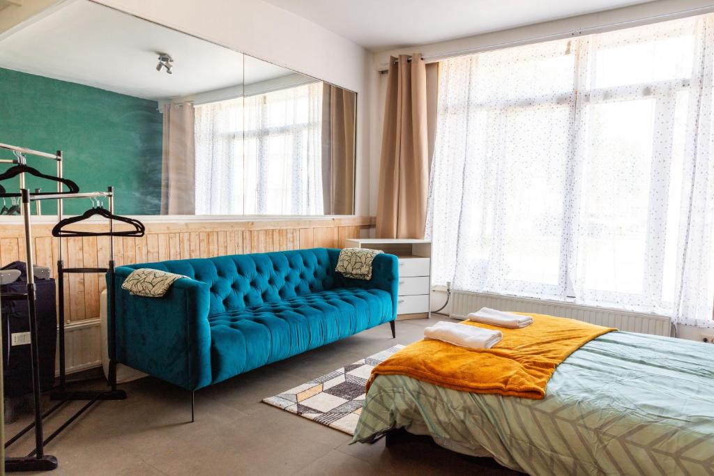 um quarto com um sofá azul e uma cama em Find yourself apartment Dunkerque em Coudekerque-Branche