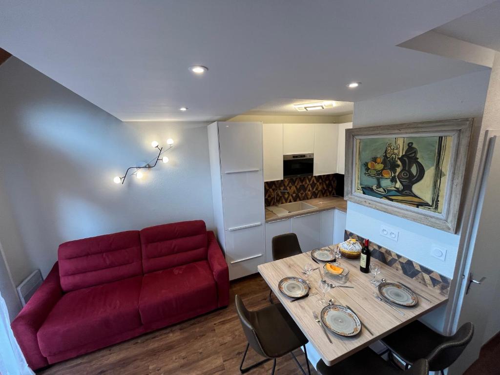 un salon avec un canapé rouge et une table dans l'établissement F2 rénové, à Saint-Lary-Soulan
