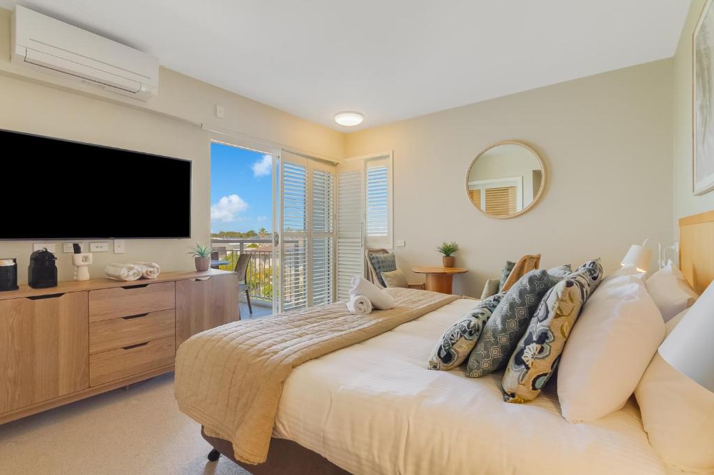 a bedroom with a large bed and a flat screen tv at Quiet Hotel Room in Mantra Salt Beach by uHoliday in Kingscliff