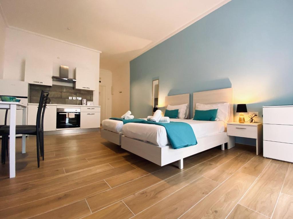 a bedroom with a large bed and a kitchen at Miami Apartments in St. Julianʼs