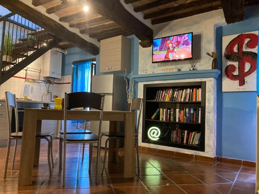 a living room with a table and a tv on a wall at Ai Muri Dipinti in Perugia