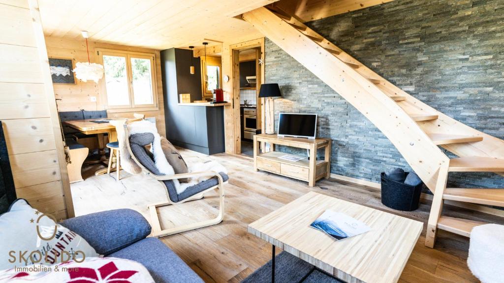 a living room with a staircase in a tiny house at Chalet Eichhornli, Riederalp Golmenegg in Riederalp