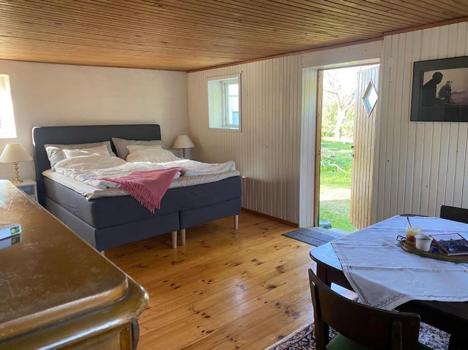 Un dormitorio con una cama y una mesa. en Lantligt boende på Österlen en Kivik