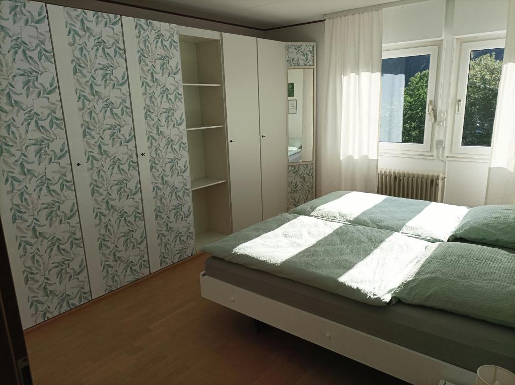 een slaapkamer met een bed met een groene en witte deken bij Große Ferienwohnung am Waldrand in Schönau