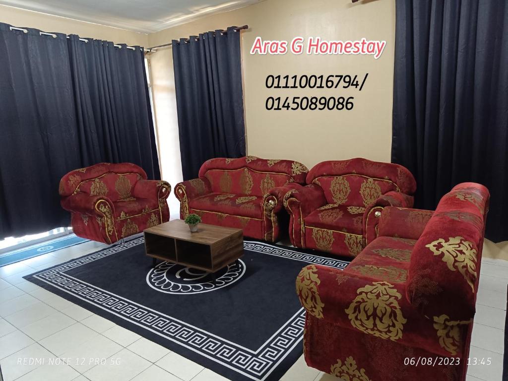 a living room with red couches and a table at Aras G Homestay in Gambang